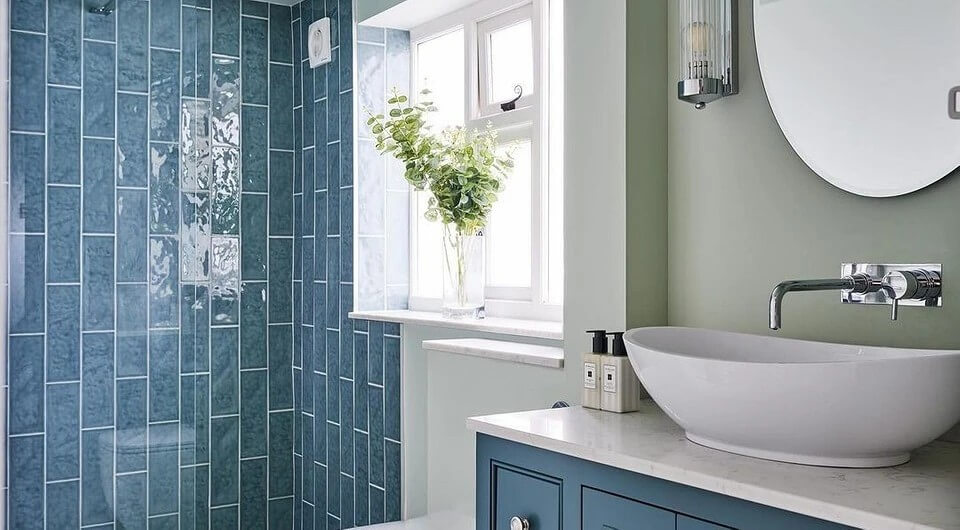 Modern bathroom with blue vertical tile shower walls, vessel sink, and minimalist vanity design